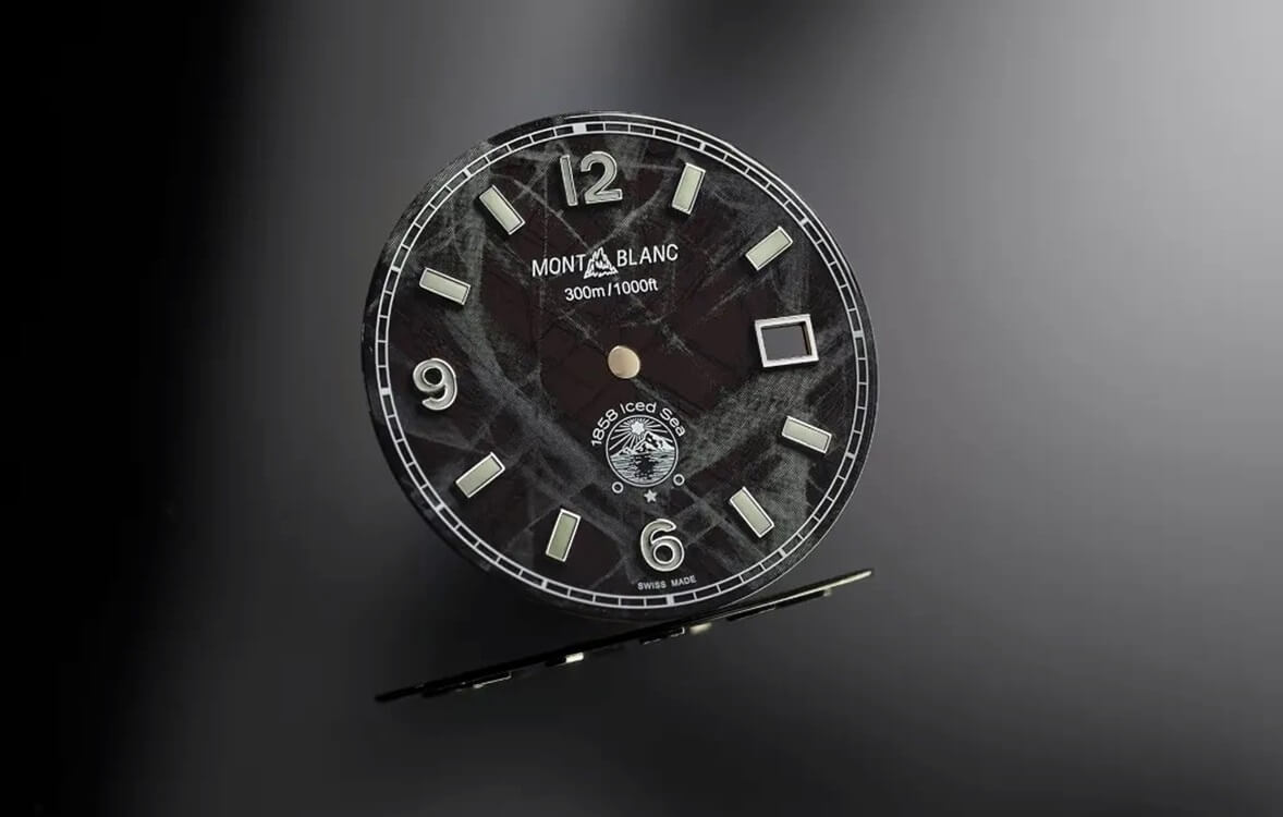Zegarki / zegarki MB url jak tytuł Tekstura lodowcowych powierzchni w zegarku. Montblanc 1858 Iced Sea Automatic Date Nowy, sportowy zegarek marki Montblanc to model, którego najbardziej wyróżniającą cechą jest tarcza o strukturze przywodzącej na myśl zamrożoną powierzchnię wody. Patrząc na jego tarczę możemy odnieść wrażenie, jak gdybyśmy mieli na nadgarstku niemalże fragment bryły lodu – linie oraz wzory utworzone na tarczy dają właśnie ten wspomniany już „zmrożony” efekt. W ramach nowej serii zegarków dostępne są wersje w z tarczami w kolorze czarnym, zielonym i niebieskim. Z oczywistych przyczyn efekt zamrożenia najbardziej naturalnie wygląda w wersji niebieskiej, gdyż ten zimny kolor właśnie kojarzy się z chłodem.  Morze Lodu Prezentowany zegarek to typowy diver. Tego typu modele na etapie projektowania tworzy się często szukając inspiracji w głębinach wód, najlepiej tropikalnych mórz i oceanów.  Jednakże marka Montblanc wybrała inną drogę.  Inspirację do stworzenia nowego modelu Montblanc 1858 Iced Sea Automatic Date przeznaczonego do nurkowania szwajcarski producent czerpał z polodowcowych jezior masywu Mont-Blanc, które znajdują się w dolinie Chamonix do Mer de Glace (Morza Lodu). Projektanci firmy byli urzeczeni teksturą tych lodowcowych powierzchni.  2 3 Podobno – takie informacje można znaleźć w materiałach prasowych, projektanci zafascynowani tym widokiem wrócili do firmy, aby spróbować znaleźć sposób na przełożenie tego, co widzieli, na wizerunek i wygląd tarczy nowego zegarka. Nie było to łatwe zadanie, ponieważ nigdy wcześniej nie stosowali podobnego motywu, a tarcza zegarka mierzy zaledwie 0,5 mm grubości, co bardzo utrudnia stworzenie wiarygodnej iluzji patrzenia w głąb lodowej struktury. Po kilku próbach firma znalazła rozwiązanie techniczne, które pozwalało stworzyć wrażenie prawdziwej głębi i jasnej barwy, które charakteryzują lodowe bryły.  Twórcy tarcz zastosowali niemalże już zapomnianą w branży technikę stosowaną przez dawnych rzemieślników zwaną „gratté boisé”. Rezultat oddaje ducha eksploracji Montblanc, zarówno pod względem przygód, do których zegarki te są stworzone, ale także sposobu, w jaki są projektowane i wytwarzane. A efekt głębi jest moim zdaniem doskonale widoczny.  4 tarcze 5 6 Tak powstał zegarek Montblanc 1858 Iced Sea Automatic Date.  Ponadczasowy kanon Stalowa koperta zegarka ma okrągły kształt z łagodnie wyprowadzonymi uszami, czyli wykonana jest na bazie klasycznego, ponadczasowego kanonu, stosowanego często przy tworzeniu także modeli sportowych. Boki koperty i jej górne powierzchnie są szczotkowana, a fazowana krawędź między nimi jest polerowana na wysoki połysk. Daje to świetny i lubiany efekt wizualny, pozwalający - moim zdaniem – w łatwy sposób ocenić jakość wykonania, która w zegarkach marki Montblanc nadal jest zapewne na bardzo wysokim poziomie, jak mogę domniemywać na podstawie dotychczasowych kontaktów z produktami tej marki.  7 koperta 8 9 Średnica koperty to 41 mm a jej grubość to 12,9 mm, co daje zegarek o bardzo uniwersalnym rozmiarze, szczególnie biorąc pod uwagę, że to rasowy diver. Obrotowa luneta wieńcząca kopertę od góry ma moletowaną krawędź i ceramiczną wkładkę w dostosowanym do tarczy kolorze, z naniesioną minutową skalą nurkową. Tarcza ma opisaną już wyżej strukturę, a jej atrakcyjny wygląd osiągnięto dzięki tradycyjnym technikom wykonania.  Na jej zewnętrznej krawędzi nadrukowano skalę minutową na wzór torowiska. Wyraziste, duże i wypełnione masą luminescencyjną indeksy są nakładane. Wskazówki, którym nadano retro stylistykę, są też odpowiednio szerokie i wypełnione substancją luminescencyjną. Te wszystkie cechy zapewniają - oczekiwaną od nurkowego zegarka - dobrą czytelność, mimo braku jednolitego tła. Masa świecąca jest w kolorze białym, ale emituje niebieskie światło, dopasowane do mroźnego charakteru modelu 1858 Iced Sea Automatic Date.  9-1 Na godzinie 3. widoczne jest okienko wskazań datownika. Pod godziną 12. nadrukowano historyczne logo marki i informację o poziomie wodoszczelności do 300 m.  Niebieski, czarny i zielony lód Trzy dostępne odcienie tarcz to niejako próba zademonstrowania charakterystyki trzech rodzajów lodu. Niebieski lód można znaleźć w Morzu Lodowym Mont-Blanc i powstaje on w wyniku włączenia pęcherzyków powietrza do lodu, podczas gdy zielony lód znajduje się na Antarktydzie i jest wynikiem obecności mikroskopijnych zakwitów glonów śnieżnych.  10 kolory 11 11-1 Czarny lód występuje, gdy lód nie ma wtrąceń ani pęcherzyków powietrza, pochłaniając w ten sposób wystarczającą ilość światła, aby wyglądać w pewnych warunkach na czarny. Może być również w kolorze czarnym ze względu na osady popiołu wulkanicznego w jego strukturze, co zdarza się w niektórych polarnych rejonach.  Wracając jeszcze do opisu elementów koperty.  Koronka jest umieszczona tradycyjnie na godzinie 3. W wyraźnie zagłębionej, czołowej powierzchni, otoczonej wąską krawędzią znajduje się śnieżynka, będąca jednym z logo marki Montblanc. Dekiel zegarka jest wkręcany i pełny, przyozdobiony reliefowym grawerem 3D przedstawiającym wizerunek góry lodowej i płetwonurka badającego wody lodowcowe poniżej. Ten wizerunek jest osiągany za pomocą techniki grawerowania, która jest rzadko spotykana na tak małej powierzchni. Grawerowanie rozpoczyna się od badania struktury metalu za pomocą lasera, aby stworzyć obraz reliefowy 3D, który zapewnia głębię i realizm. 12 dekiel 13 Nowe zegarki Montblanc dostępne są na gumowych paskach w kolorze korespondującym z tarczą, z czarnymi krawędziami. Paski zapinane są na podwójnie składaną klamrę. Przy mocowaniu mają szerokość 20 mm, a przy zapięciu 18. Druga opcja to bransoleta, zwężana, co nieczęsto się zdarza, do 16 mm. Ma ona też opcję szybkiego dopasowania.  Zmiana paska i bransolety jest łatwa i bez narzędziowa.  Klamry paska i bransolety zwalniane są przyciskami.  Mechanicznym sercem nowej kolekcji czasomierzy jest mechanizm z automatycznym naciągiem MB 24.17, wykonany na bazie sprawdzonego werku Sellita SW200-1.  Montblanc 1858 Iced Sea Automatic Date – dostępność i cena Warto wspomnieć, że zegarki Montblanc 1858 Iced Sea spełniają także rygory normy ISO 6425 do nurkowania, co z tego atrakcyjnego, sportowego modelu czyni jednocześnie certyfikowany przyrząd do nurkowania.  14 Oprócz tego ważnego certyfikatu bezpieczeństwa, każdy egzemplarz przed dostarczeniem do klienta przeszedł 500-godzinny test Montblanc Laboratory, aby upewnić się, że jest odporny na wstrząsy, działania pól magnetycznych, temperaturę i wodę. Cena Montblanc 1858 Iced Sea Automatic Date na pasku gumowym wynosi 2990 euro a w wersji z bransoletą 3200 euro, co oznacza odpowiednio około 14 000 i 15 000 złotych. Adrian Szewczyk 